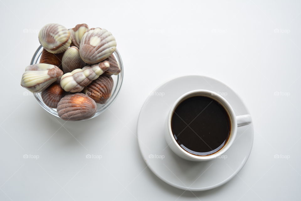 coffee cup with chocolate candy top view on a white background