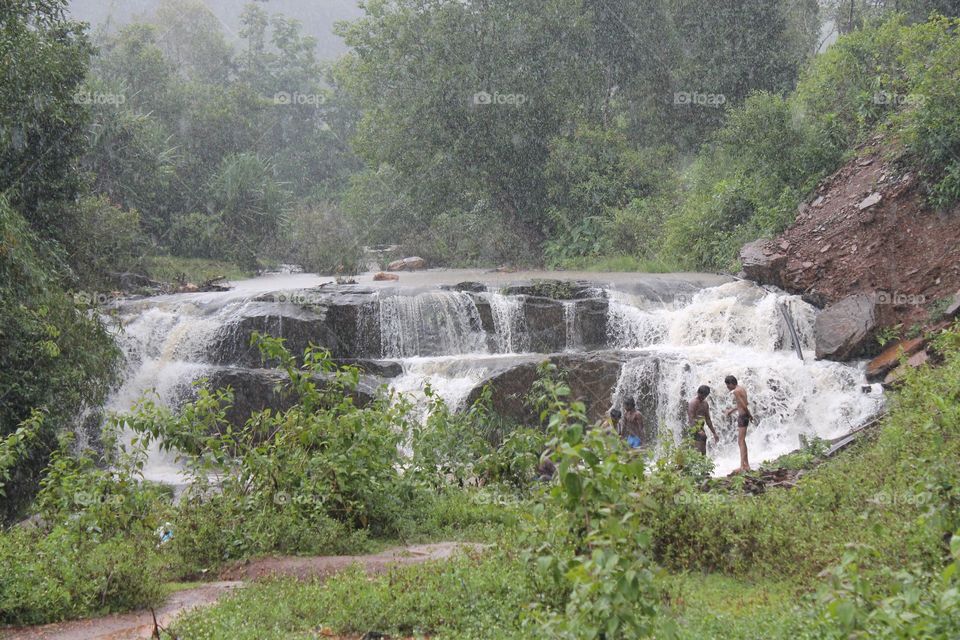 wide waterfall flowing in the center of the forest