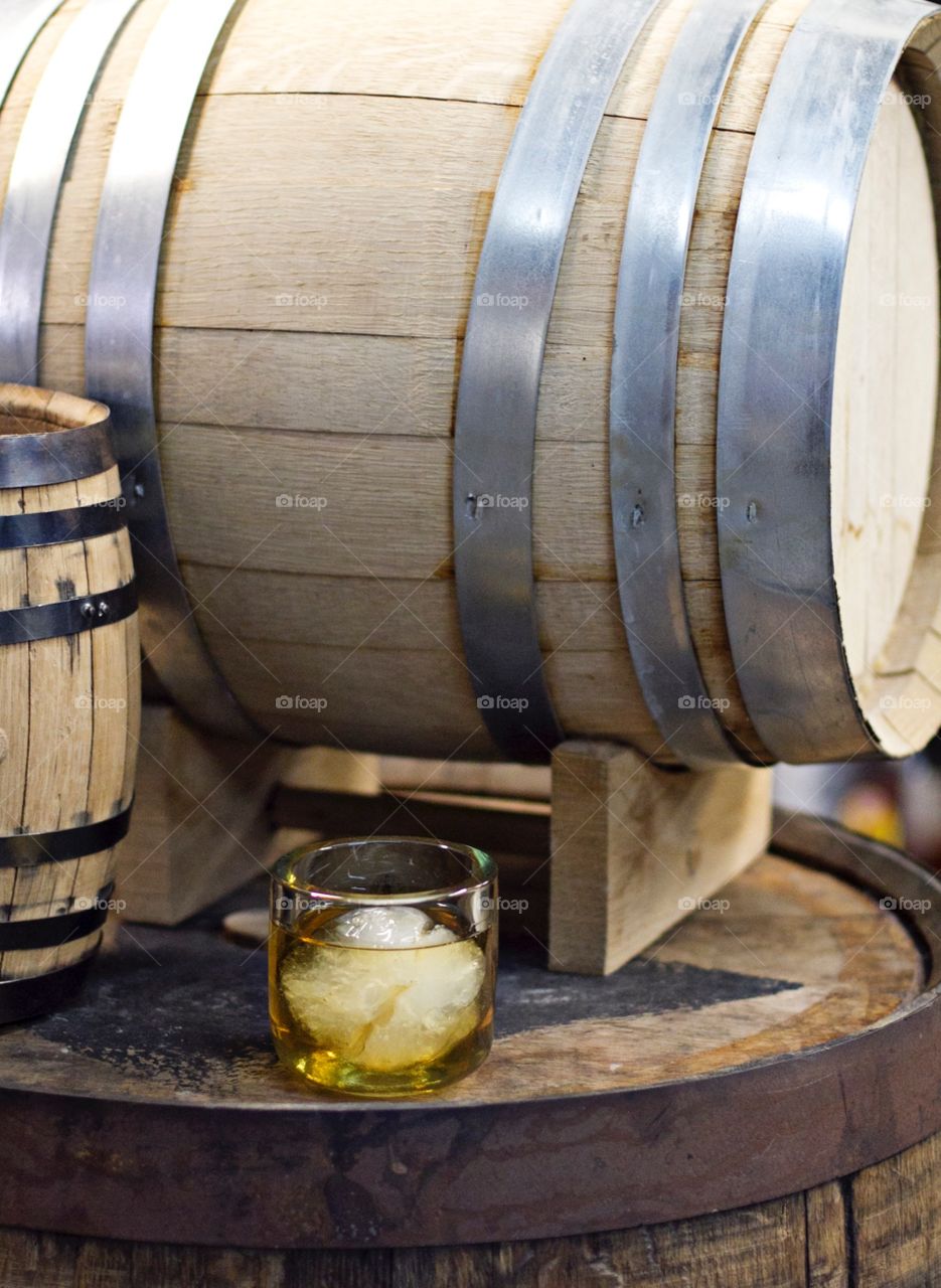 Glass of whiskey with barrels 