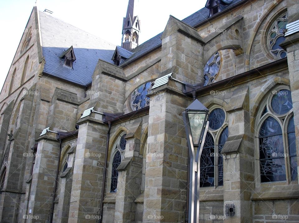 Details of side wall with stained glass windows of a little modern gothic church