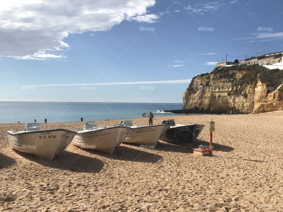 Fishing Boats on the beach. The blue skies above the Algarve coastline. 
