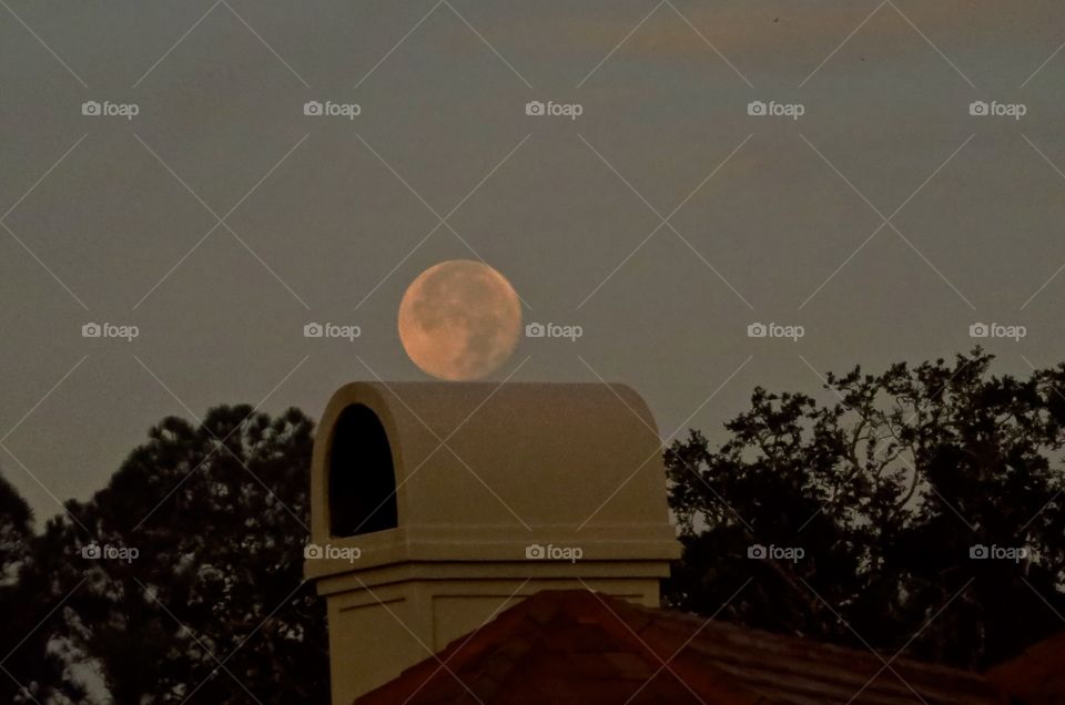 December super moon perched on a house
