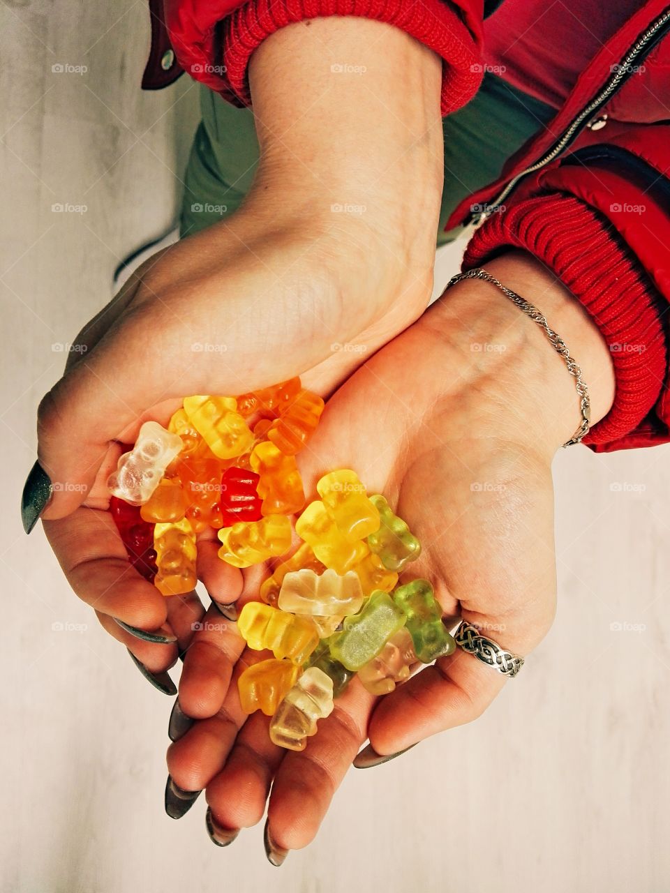 sweet colorful gummi bears holding in hand