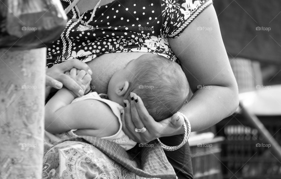 Mother feed baby while she’s working , The most beautiful life shot of my photo