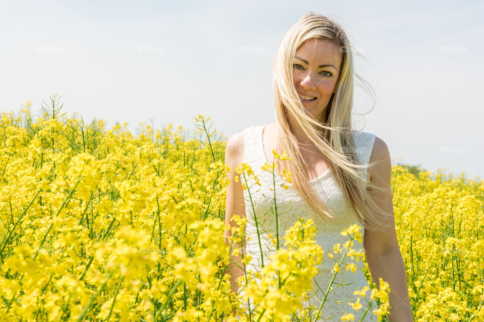 Woman 30 years old walking in a Raps field outside Malmö in Sweden.