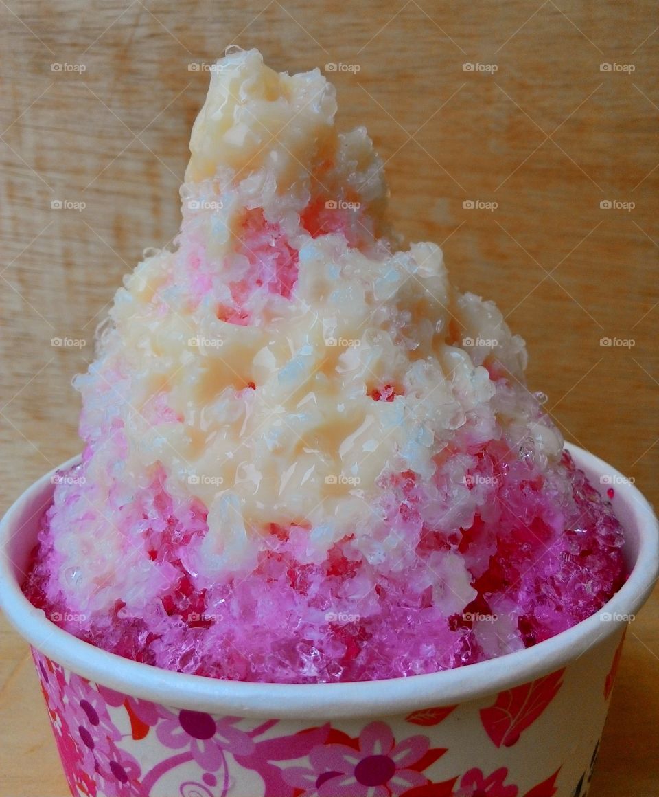 shaved ice with syrup and milk. shaved ice with syrup and milk in the cup