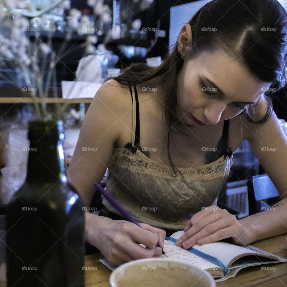 Close-up of a woman writing in diary