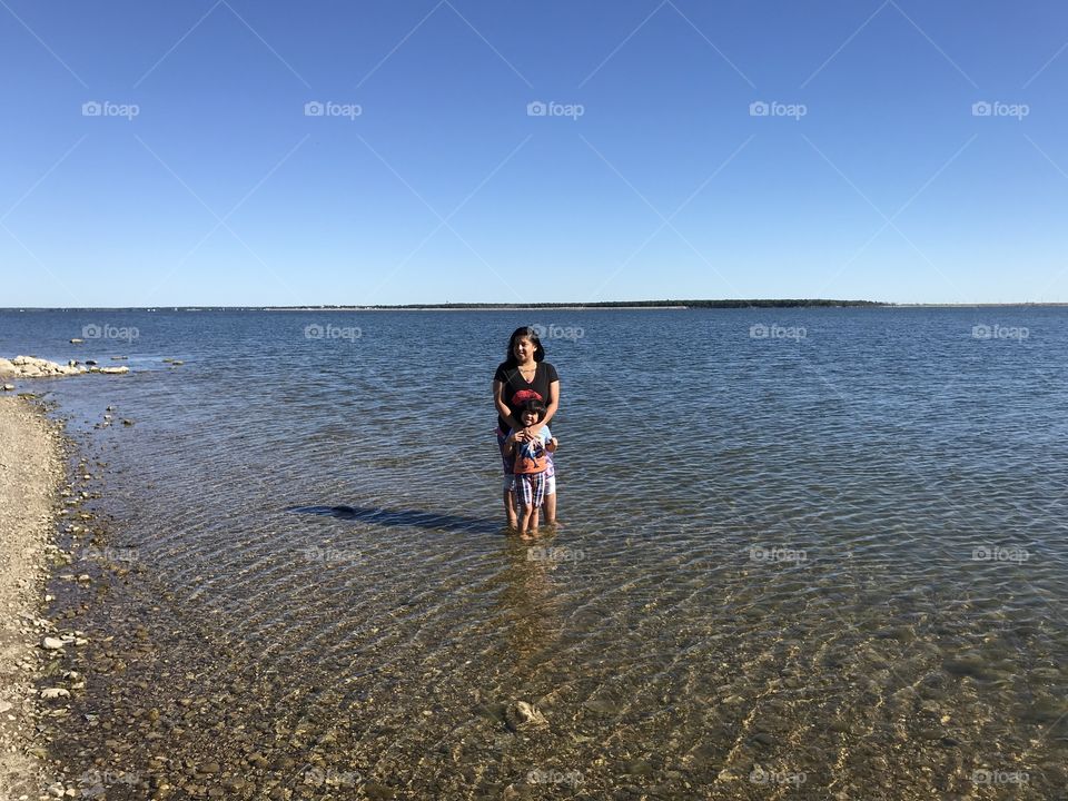 Lakota woman & her son standing in Spirit Lake by the Spirit Lake Casino & Resort
