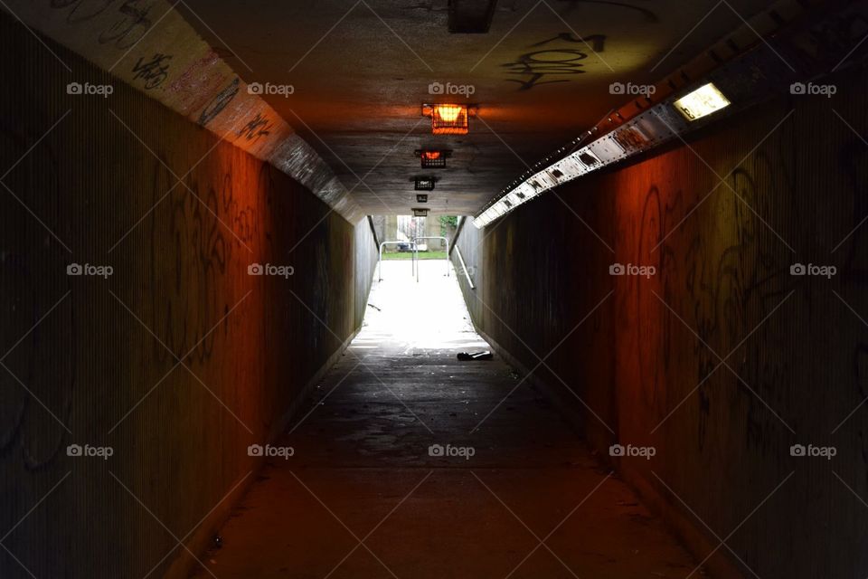 Underpass lit dimly by side lights that create a warm glowing effect.