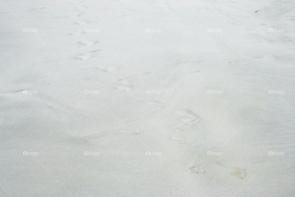 Footprints in white sand