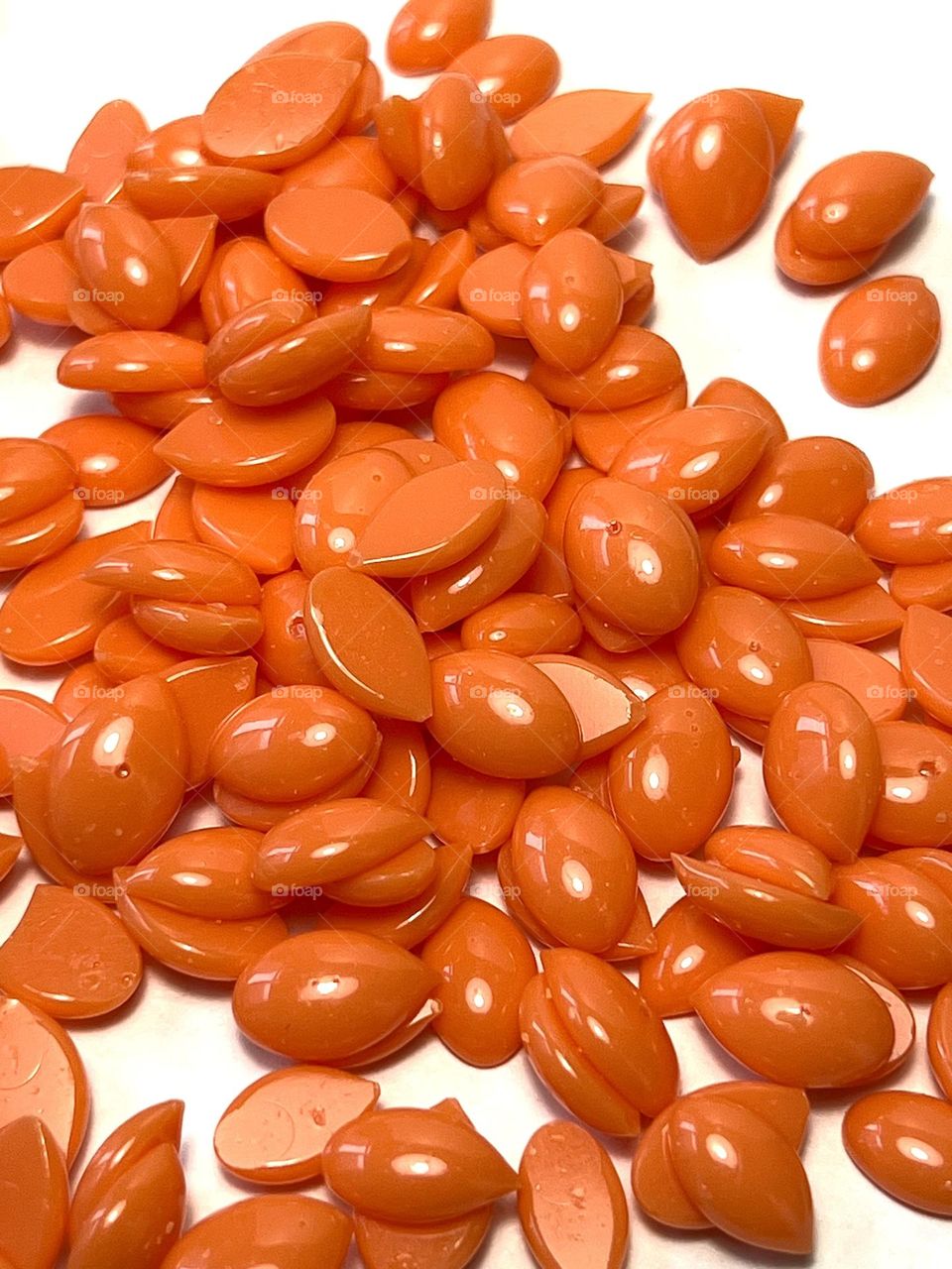 Orange color hot wax for depilation in granules on white background