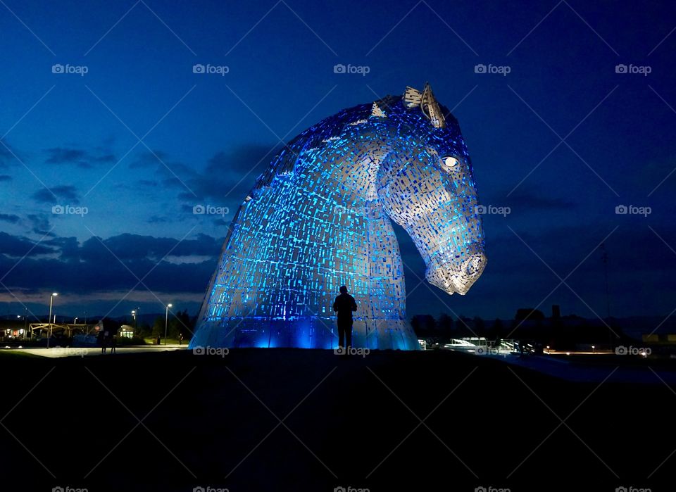 BLUE lights lighting up The Kelpies ... loved visiting these so much during the day I revisited at night to find them even more spectacular lit up in different colours ...Silhouette of my son fed up waiting for me to finish my shoot 😂