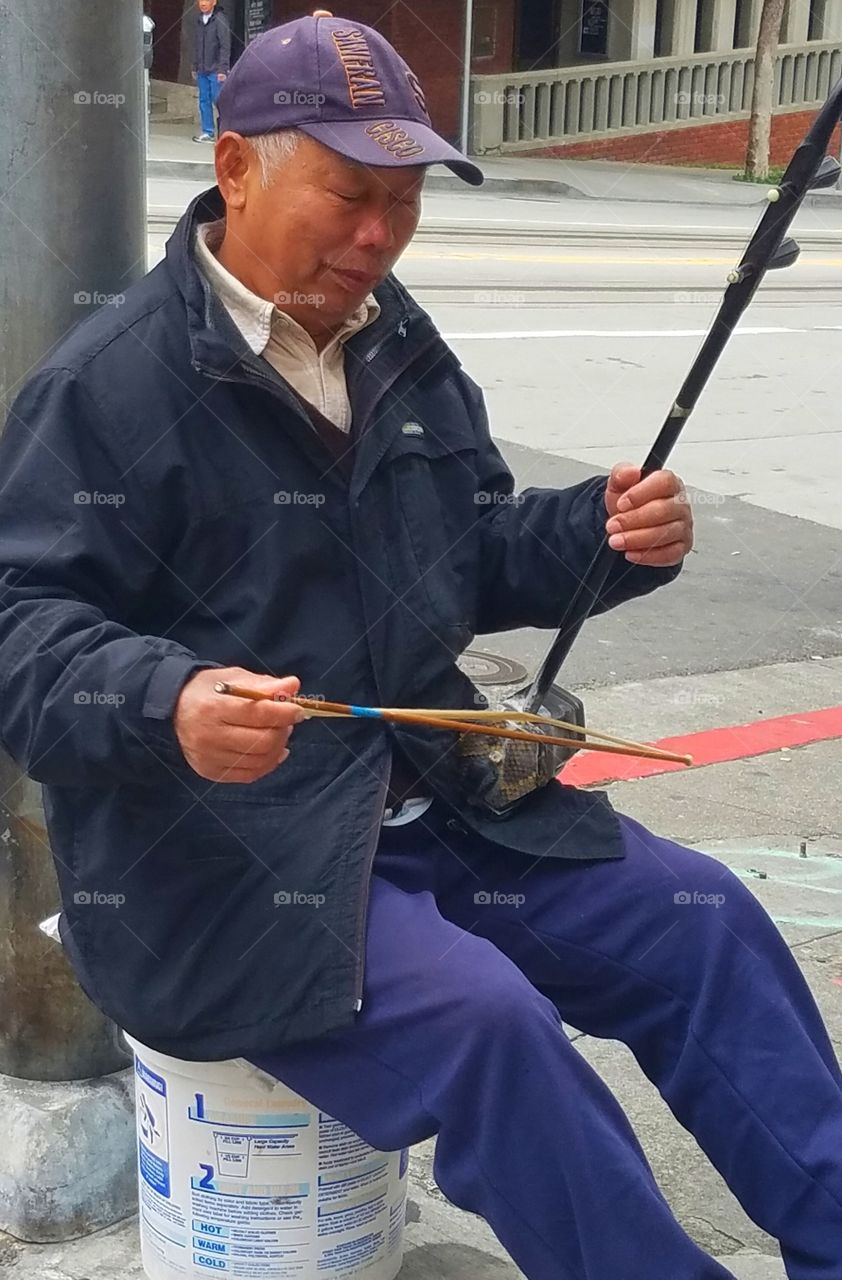 Senior man playing music on street