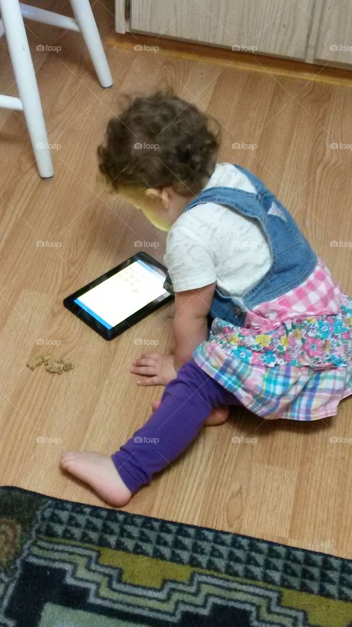 reading. toddler reads electronic book