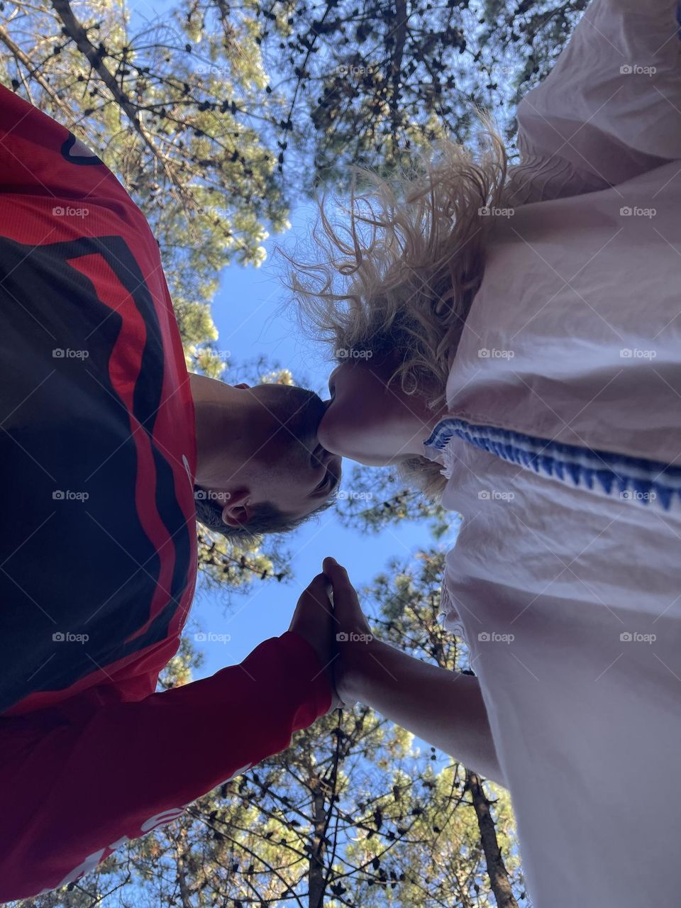 Pareja enamorada ente los pinos de un bosque y el cielo infinito como el amor 🧡