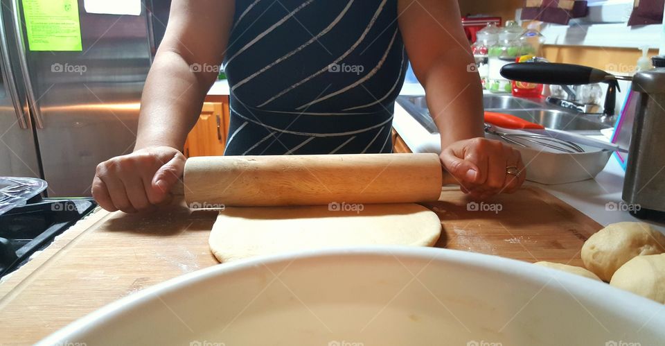 Close-up of woman rolling dough with rolling pin