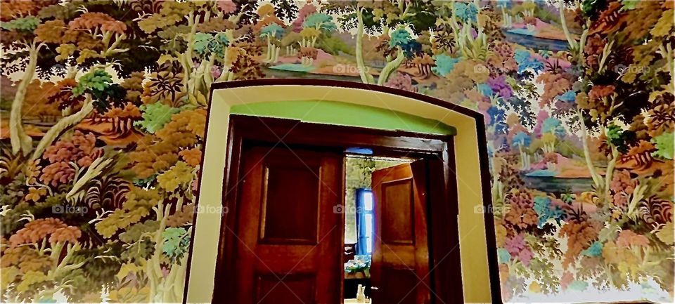 The “Haus Heuport” has several rooms, each more lavishly decorated than the previous one. The walls here are covered with an old style broquet printed wall paper featuring plants and a rural countryside. 2023. Hypnotic Productions