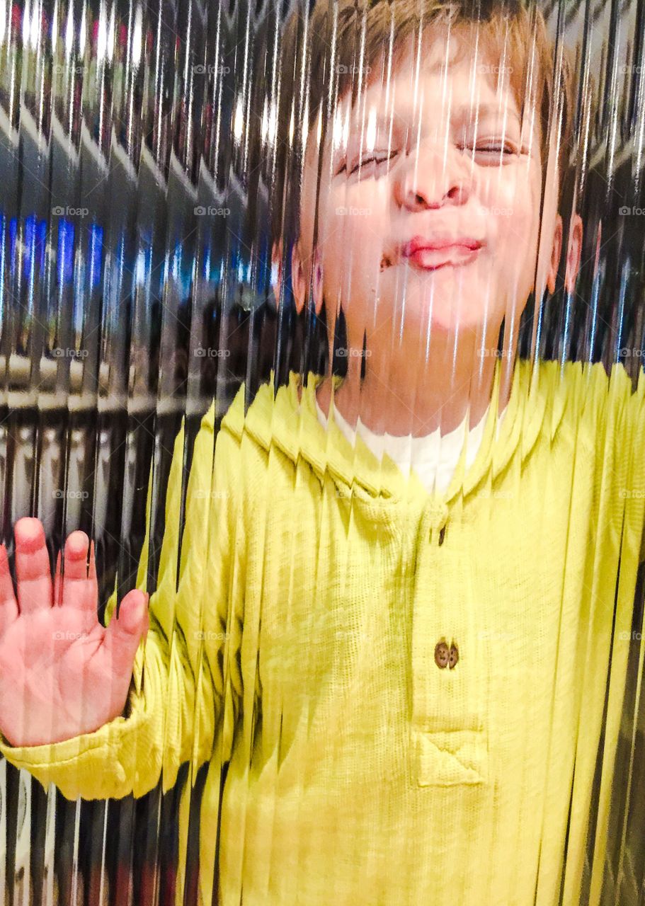 Boy standing behind glass window