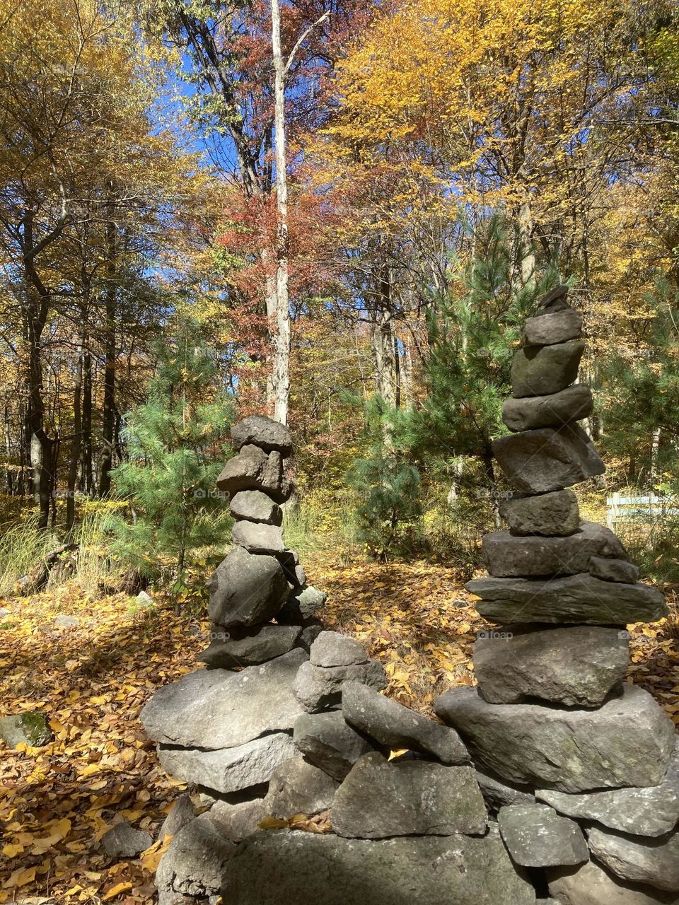 Two beautifully balanced stone stacks,often called cairns or prayer stone stacks,marking the starting point of a hiking trail. 