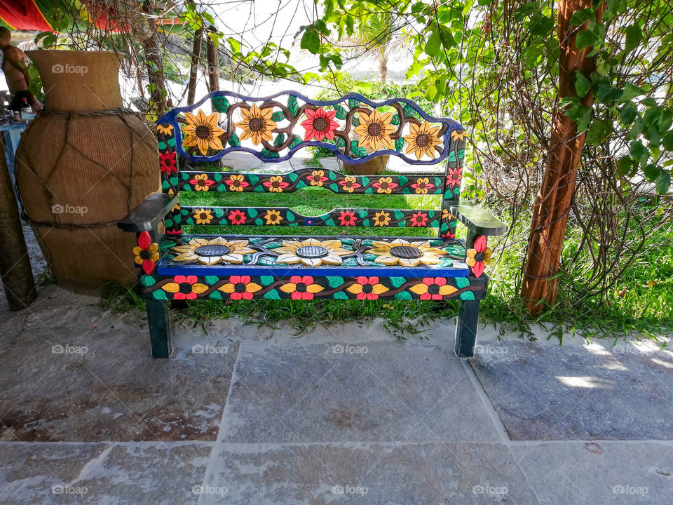 Coloured bench with flowers. 
