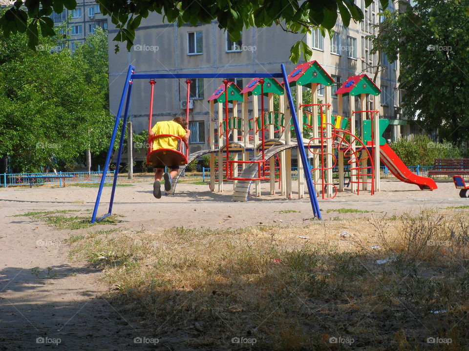 boy swinging on a swing at the playground