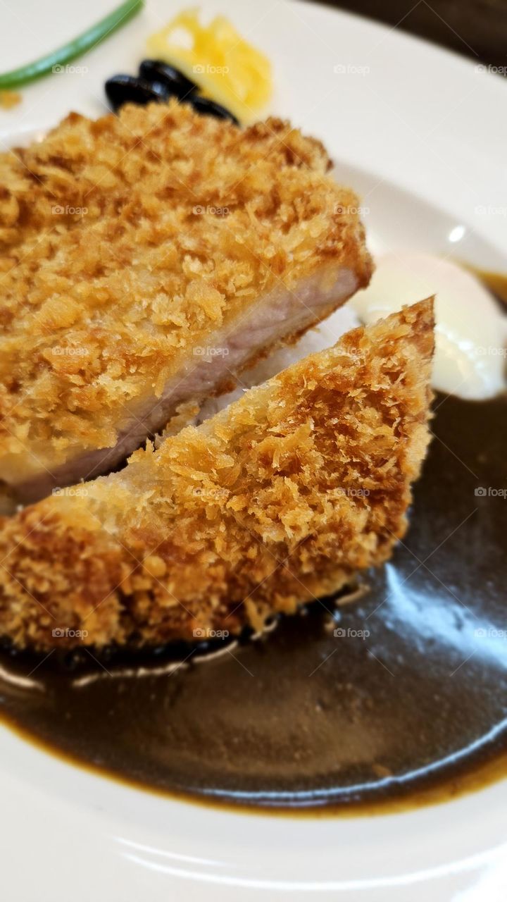 a dish of curry rice with fry pork