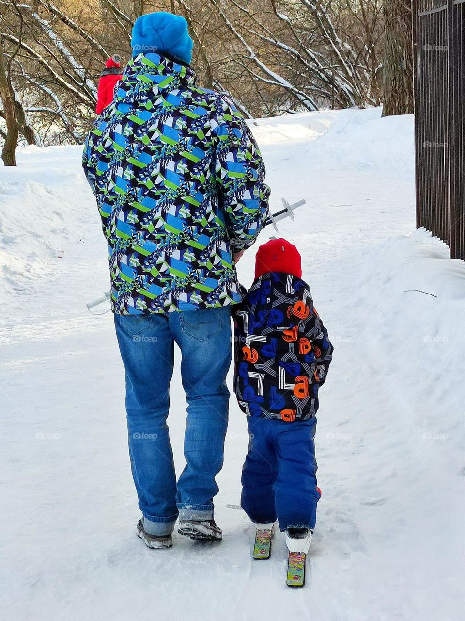 Motivation for a healthy lifestyle.  Snow trail.  Dad and little son.  Skiing boy.  Dad teaches son how to ski