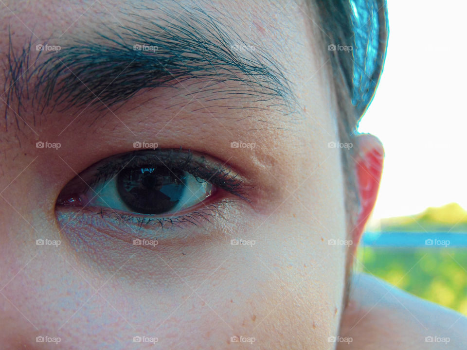 close up picture of a girl's eye with the photographer reflected in the eye
