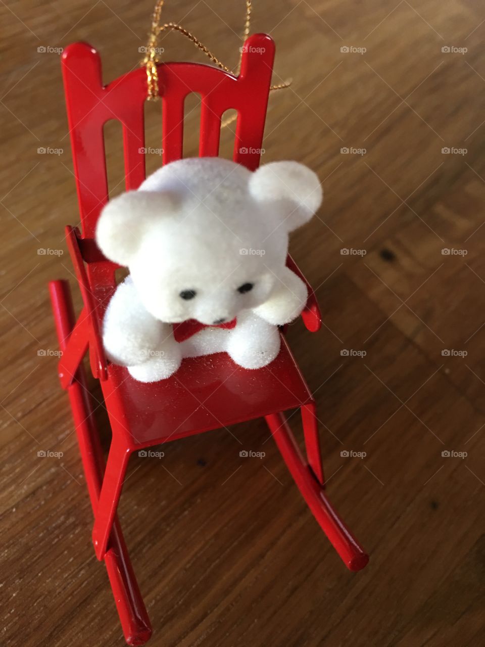 Miniature white teddy bear in a rocking chair 