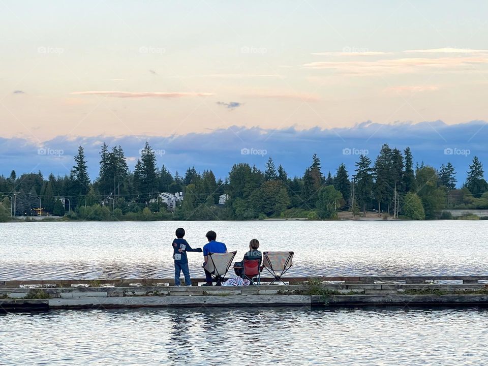 Family doing fishing on the lake in the evening 