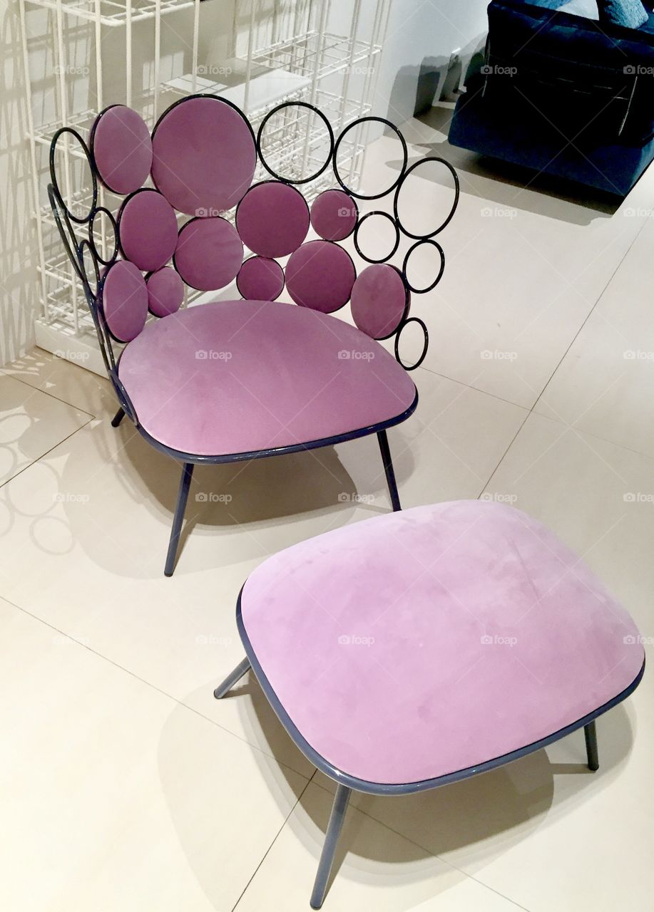 Contemporary, modern interior design. Pink chair and footrest