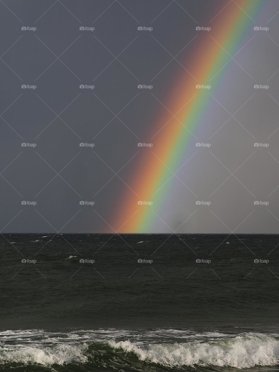 Rainbow over the sea after rain in stormy weather, nobody 