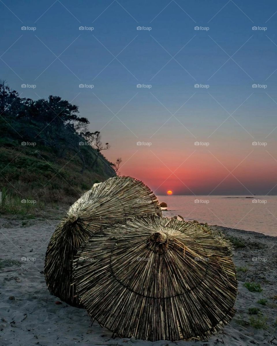Where the rustic charm of the beach meets the fiery kiss of the setting sun, tranquility finds its perfect horizon