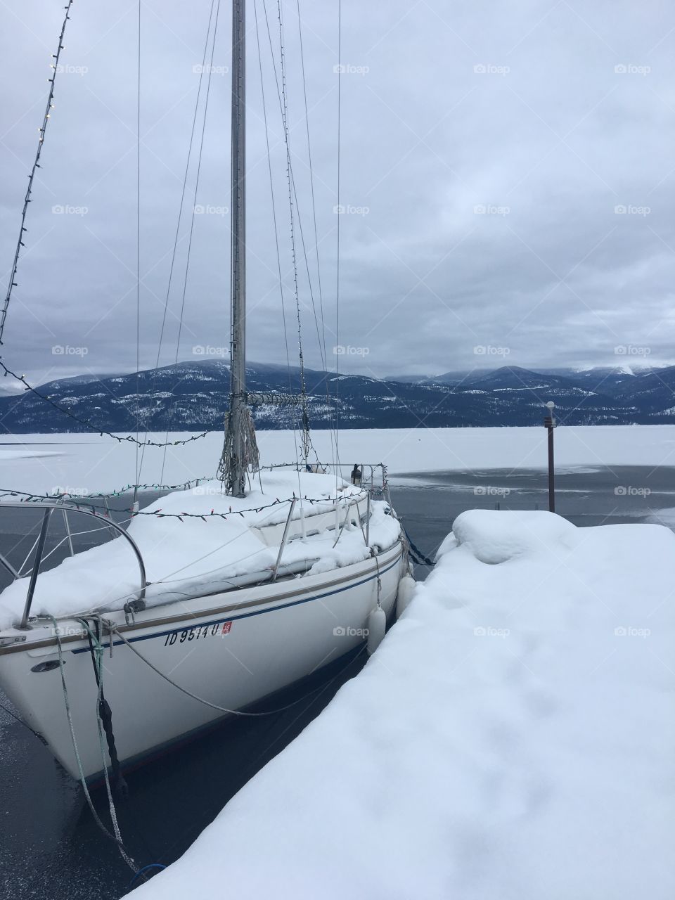 Sail boat covered in snow on lake