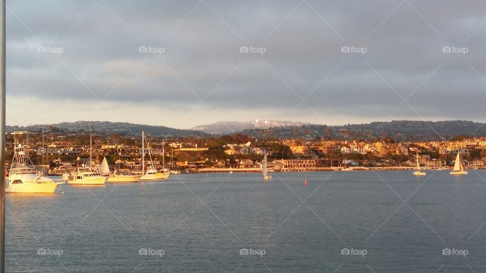 Newport Harbor, Newport Beach, CA . Moments before sunset, view from a yacht looking toward Newport coastline