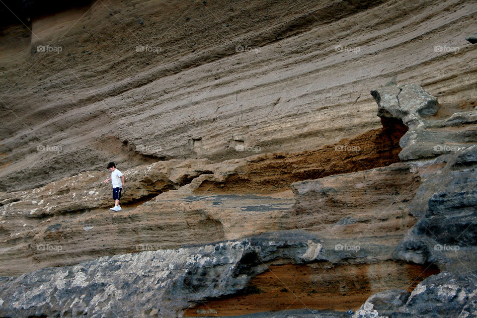 Boy walking on a rock