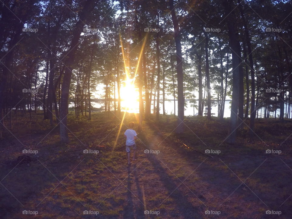 Traverse city area, Michigan in the summer. This was a family vacation and my nephew is walking to the sunset on our lake!