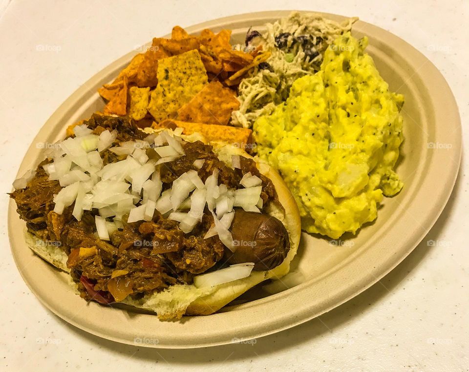A chili dog and potato salad supper served at a church gathering. It looks so good that it tastes good.