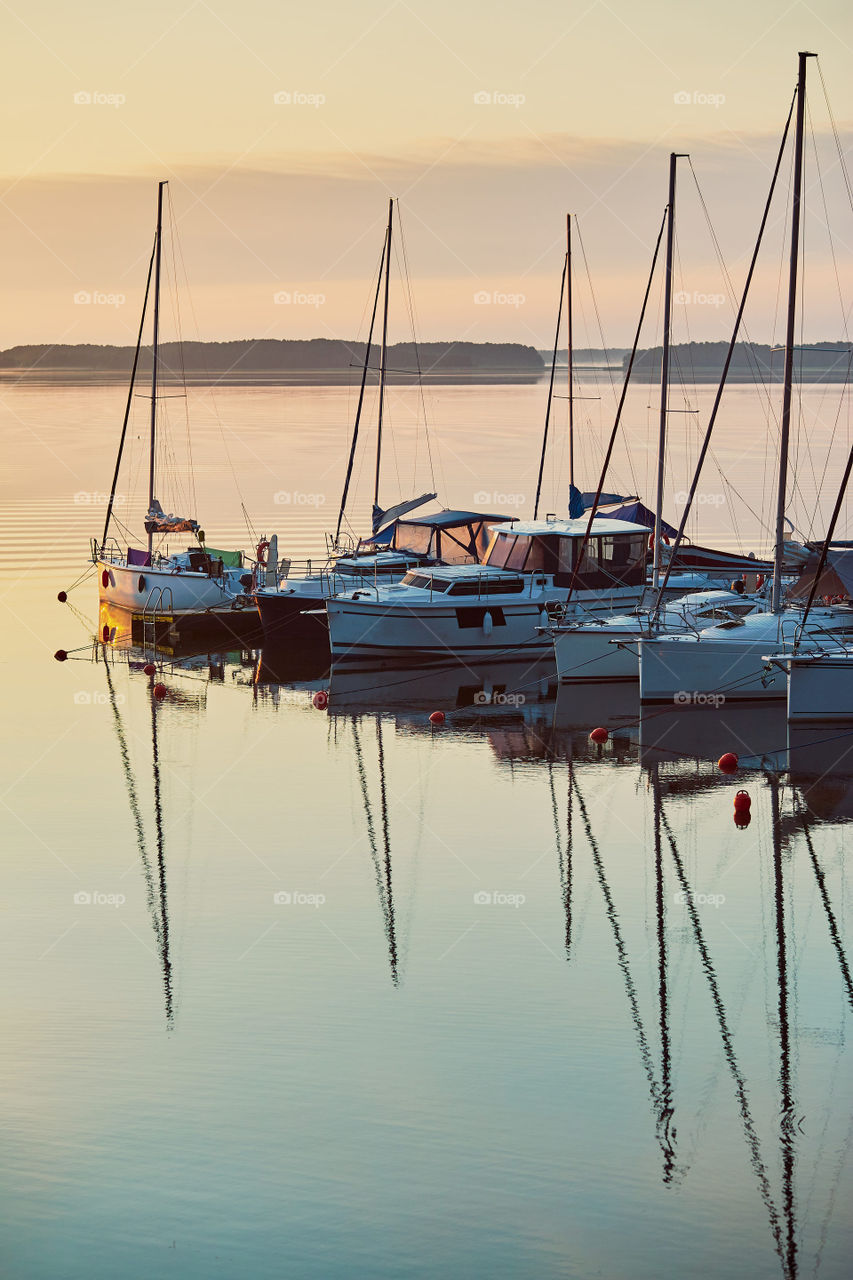 Yachts and boats moored in a harbour at sunrise. Candid people, real moments, authentic situations