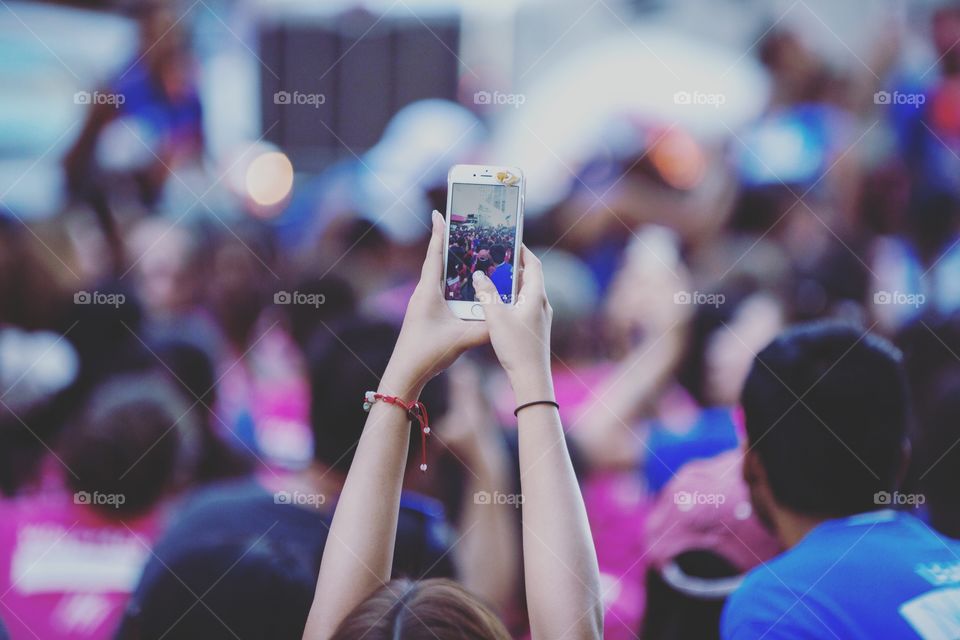 Working hands taking a photo of a crowd from above