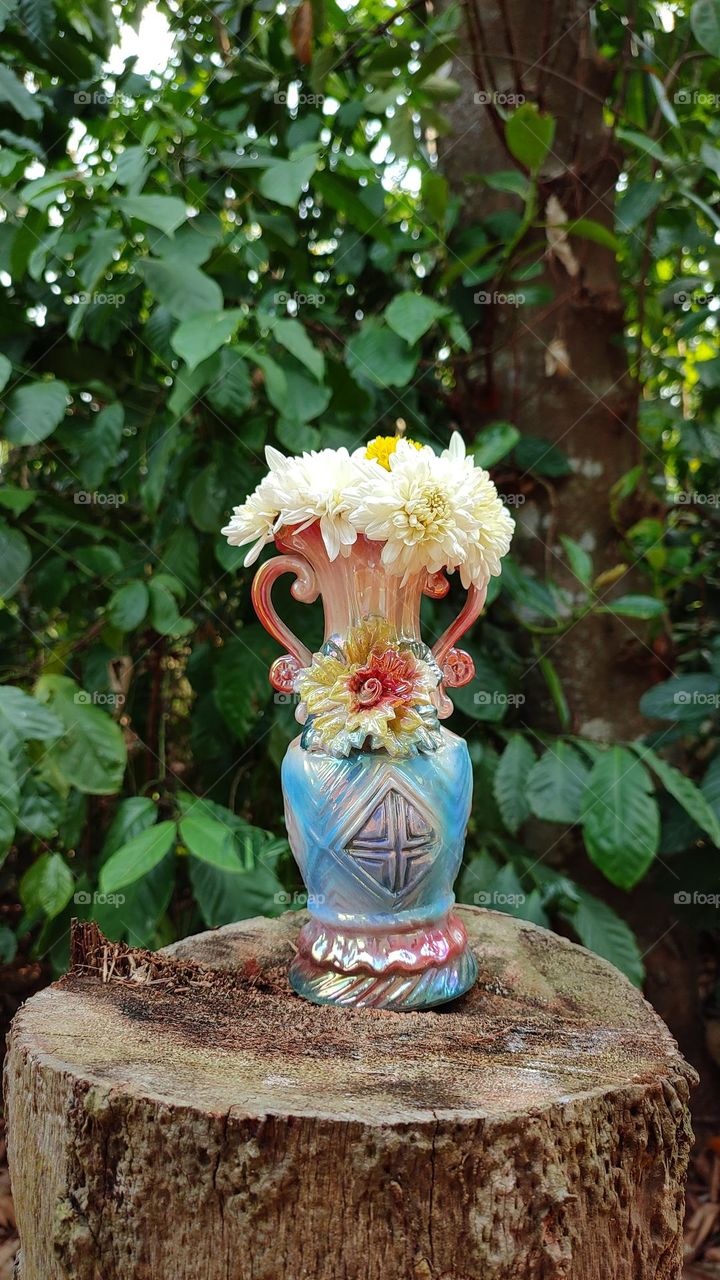 Beautiful white flowers in a colourful flowerpot with a flower sculpture, Flowers in a vase, colourful vase, white flowers in a vase