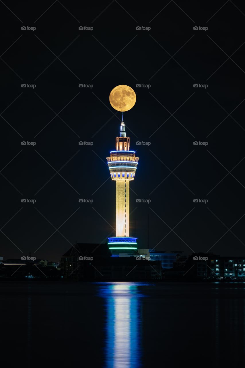 Full moon above Samut Prakan city tower in Thailand