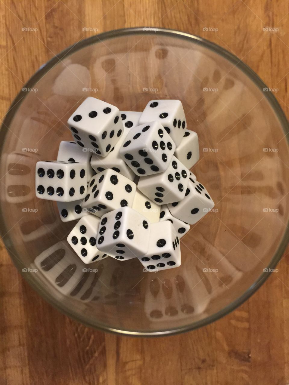 Dice in a wine glass with reflection form the dice
