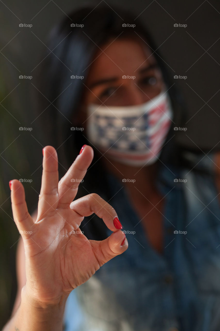 Beautiful brunette in a protective mask painted by the American flag.  Independence Day in America.  Flag.  Love.  A life.  The mask is made by hand