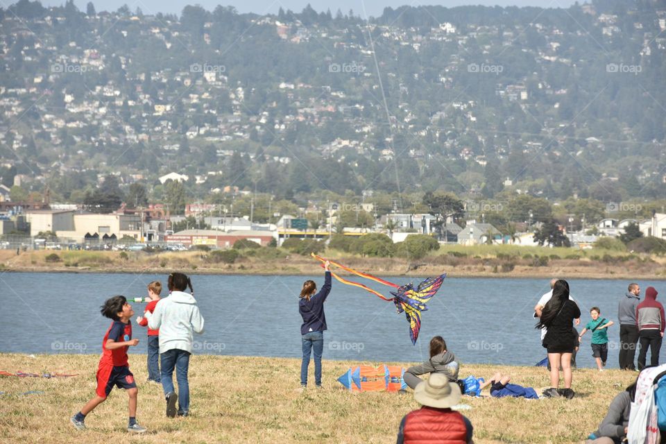 Girl trying to launch a kite in a park.