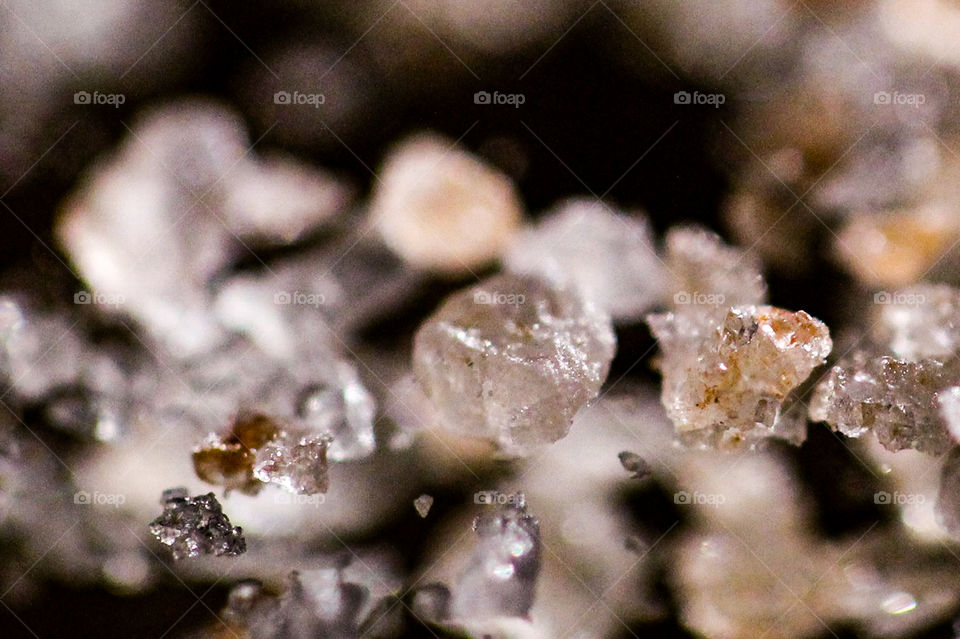 Macro of Himalayan pink salt crystals sitting on a mirror. The angle from the reflections makes the crystals look like they are floating in the air!