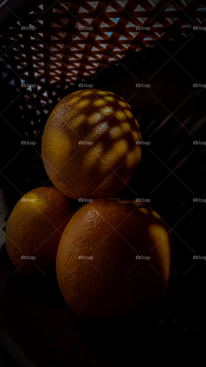 oranges in the dark. shadows on the oranges.