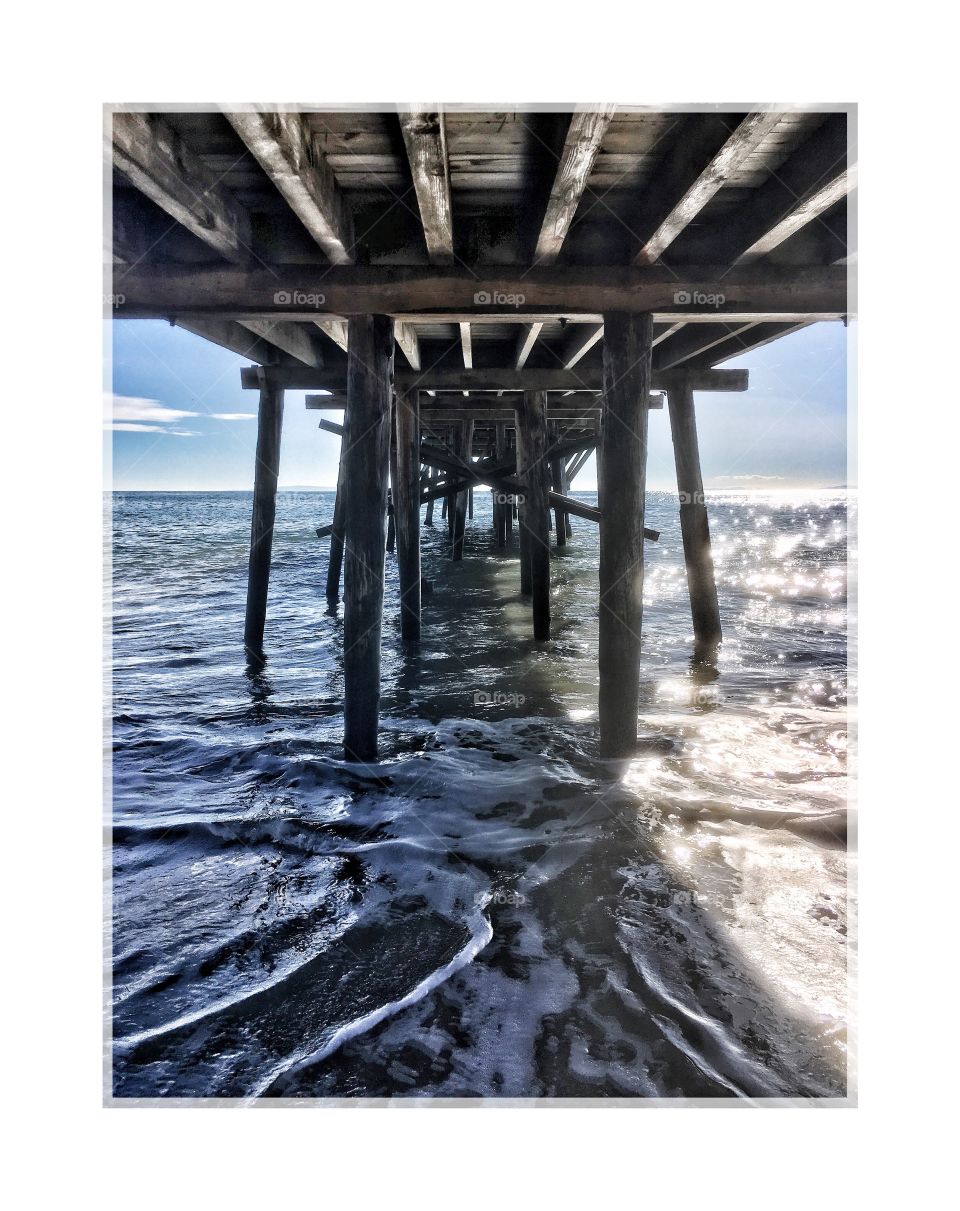 Underneath of a pier over sea