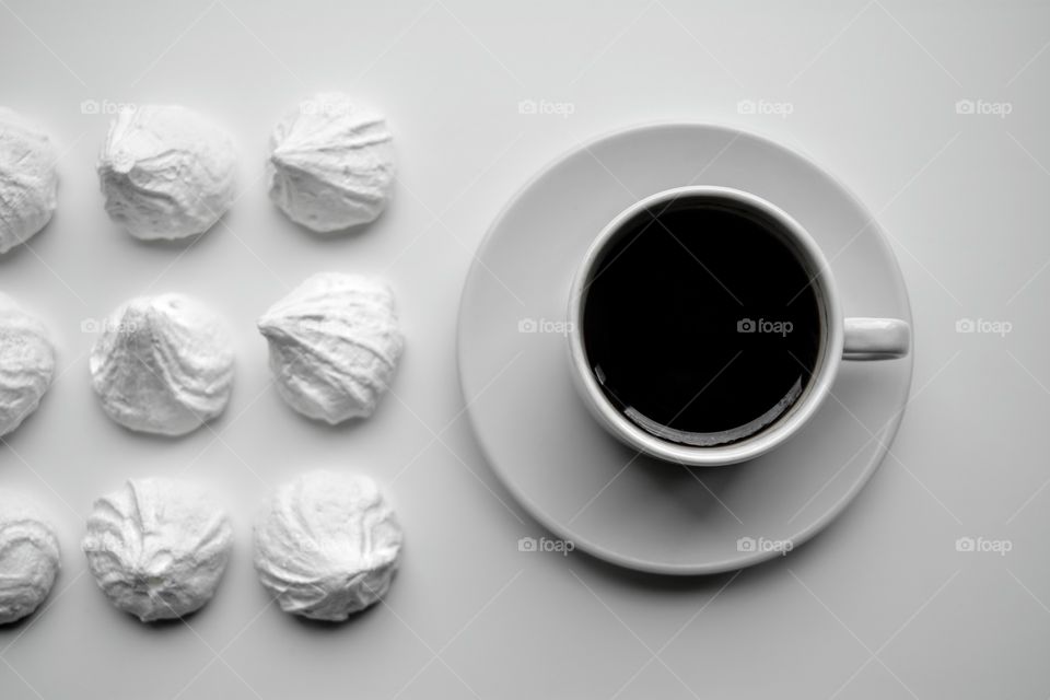 cup of coffee and sugar meringues top view black and white background