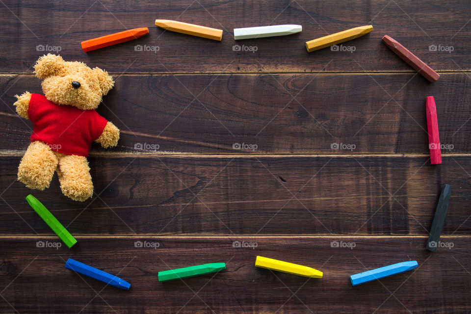 Blank blackboard and Teddy Bear on wooden table.Template mock up for adding your design and leave space beside frame for adding more text.